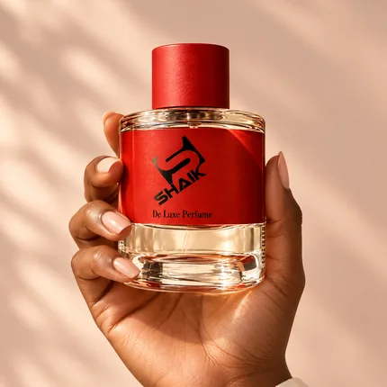 Hand holding a Shaik unisex perfume with red cap and label