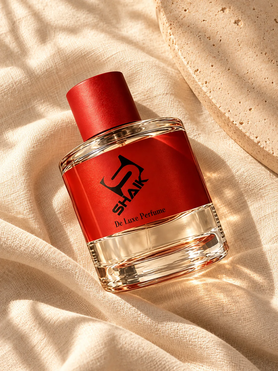 Shaik unisex perfume with red cap and label on linen