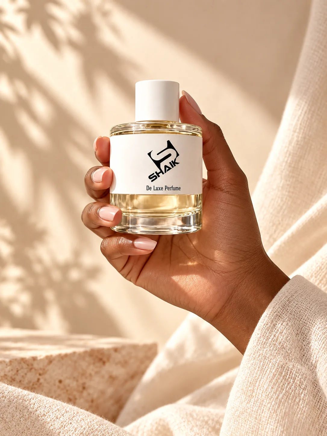 Hand holding a Shaik women's perfume with white cap and label